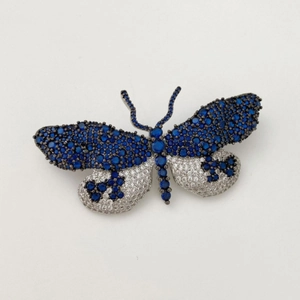 Broche papillon exquise avec cristaux bleu foncé et blancs sur base en métal noir