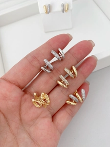 Detailed macro view of U-shaped double row stud earrings in gold and silver finish