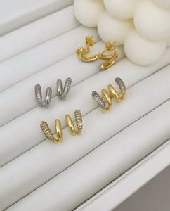 Detailed macro view of four asymmetric geometric zircon stud earrings on jewelry tray