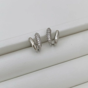 Macro shot of micro-pave cubic zirconia on silver double-hoop asymmetric earrings
