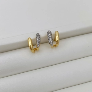Detail view of asymmetric U-shaped gold earrings with micro-pave cubic zirconia crystals
