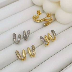 Asymmetric micro-paved zircon claw earrings with polished gold and silver finishes