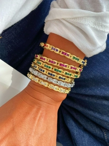 Close-up of luxury gold and silver plated bracelets set with colorful zircon gemstones