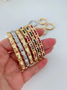 Detailed view of gold and silver chain bracelets with vibrant square-cut zircons