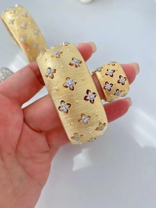 Dettaglio macro del set bracciale e anello placcato oro 18K spazzolato con fiori di zircone