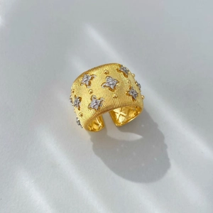 Dettaglio anello largo in oro 18K spazzolato con accenti di diamanti a forma di stella