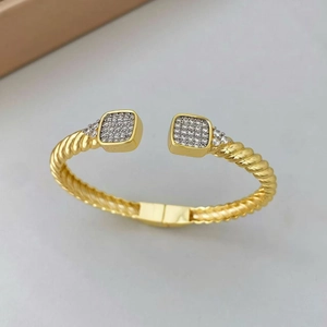 Vue détaillée du bracelet torsadé doré avec extrémités carrées pavées de zircons