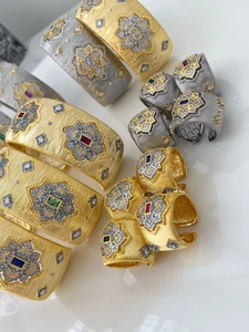 Dettaglio del set bracciale e anello in metallo spazzolato con pietre di zircone colorate