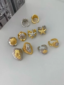 Detailed macro view of 18k gold plated ocean rings with starfish and shell elements