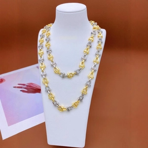 Industrial two-tone gold and silver link chain necklace on a jewelry bust display