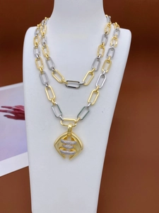 Detail einer zweifarbigen Metallkette mit geometrischem Diamantanhänger auf Display