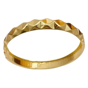 Polished gold geometric faceted ring with a sharp minimalist wave pattern on white background