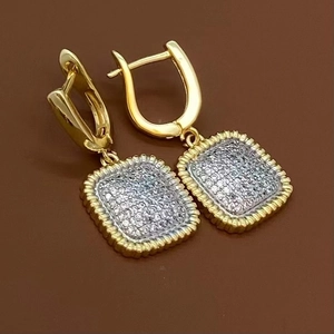 Détail macro de boucles d'oreilles dorées avec pavé de zircons cubiques scintillants