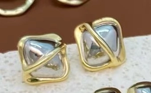 Vista macro de pendientes cuadrados minimalistas con baño de oro de 18k en dos tonos