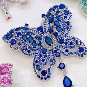 Macro-opname van de fonkelende blauwe zirkoon vlinderbroche met een druppelvormige hanger
