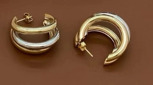 Detailed macro view of triple layered mixed metal hoop earrings in gold and silver finish