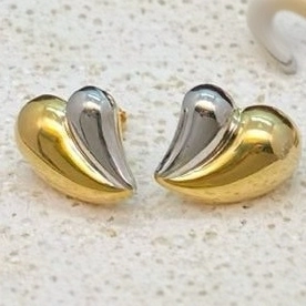 Elegant gold and silver dual-tone heart-shaped stud earrings on a textured stone surface