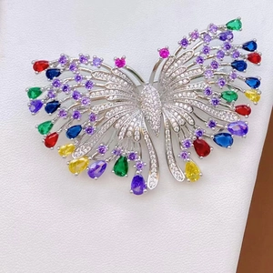 Micro-pave butterfly brooch featuring colorful gemstones and a polished silver base