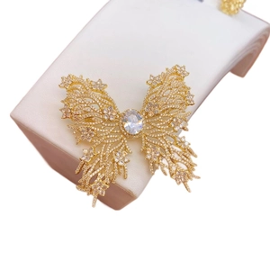 Sparkling butterfly brooch with green zircon and hollow gold plating on a white stand