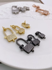Macro detail of 18K gold plated zircon pave lock pendants for DIY jewelry making
