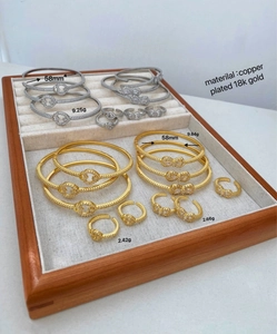 Details von 18 Karat vergoldetem Armreif und Ring-Set mit Zirkonia und verschlungenen Ringen