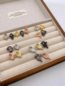 Detailed view of 18K gold plated lobster clasps with heart and Hamsa hand motifs for DIY