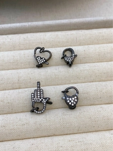 Macro shot of 18K gunmetal lobster clasps with heart shapes and zircon micro-inlay