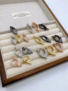 Dettaglio di chiusure a moschettone con zirconi micro-pave in oro, argento e oro rosa