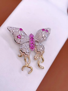 Prachtige vlinderbroche met pavé zirkoonkristallen en roze kwastjesontwerp
