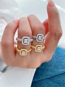 Close-up of stacked square halo rings with baguette stones and threaded bands