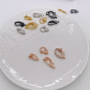 Chiusure a moschettone assortite in oro e argento con zirconi su vassoio in ceramica