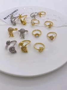 Detailed top view of ocean themed adjustable rings with shell and crab motifs on a white plate