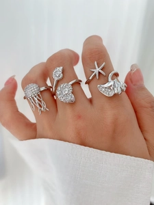 Detail of silver rings featuring jellyfish, shell, and starfish with white zircons