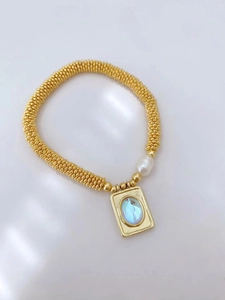 Golden beaded bracelet with freshwater pearl and blue rectangular gemstone pendant