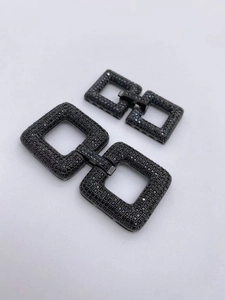 Macro detail of black pavé-set rectangular jewelry clasps with industrial aesthetic