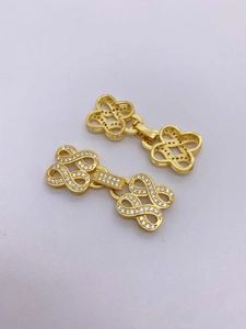 Dettaglio della chiusura a fiocco in oro 18K con zirconi e retro in metallo traforato