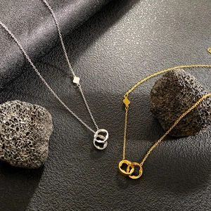 Elegantes collares de oro y plata con trébol de cuatro hojas sobre fondo de piedra oscura
