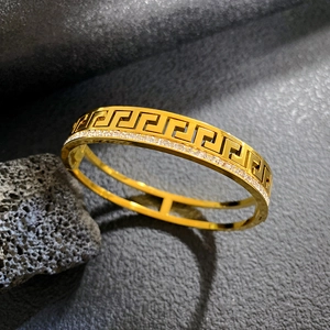 Double-layer gold stainless steel bangle featuring Greek meander pattern and pavé zircons