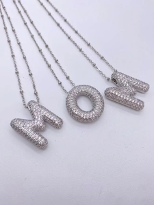 Détail des colliers MOM en argent ornés de cristaux de zircone scintillants pavés