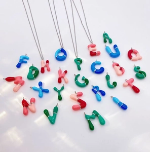 Macro detail of dopamine bubble letter pendants with colorful balloon style 3D effect
