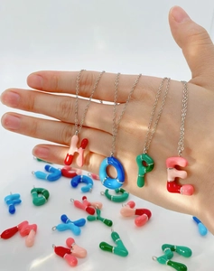 Macro detail of colorful dopamine bubble letter pendants forming the word HOPE on a silver chain