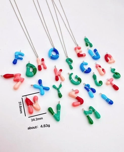Detail view of colorful bubble letter necklace with enamel pendant size specifications