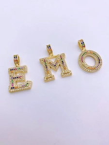 Close-up of hip hop square zircon alphabet pendants in gold with colorful rainbow stones