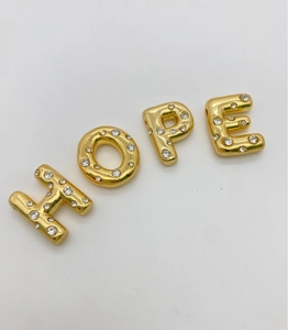 Nahaufnahme der HOPE-Buchstaben aus 18K vergoldetem Kupfer mit Zirkonia-Besatz