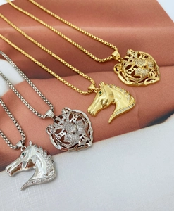 Detailed macro view of 18K gold and silver tiger and horse head pendants with box chains