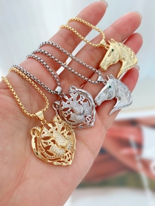 Close-up of 18K gold plated hollow tiger and horse pendant with pave-set zircon stones