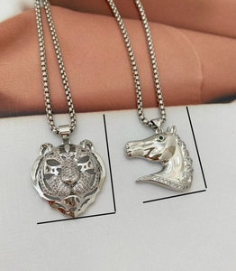 Detailed close-up of hollow tiger head and horse pendants with inlaid rhinestones