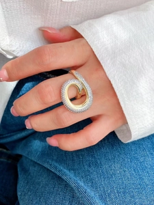 Nahaufnahme eines breiten Goldrings mit zwei Reihen Zirkonia im Wellendesign