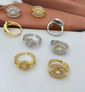 Makroaufnahme von Gold- und Silberblumenringen mit Zirkonia auf Satin-Stoffhintergrund