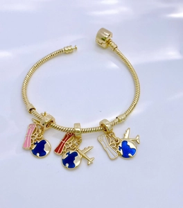 Detail eines goldenen Schlangenarmbands mit rosa Emaille-Anhängern und einem Globus-Anhänger